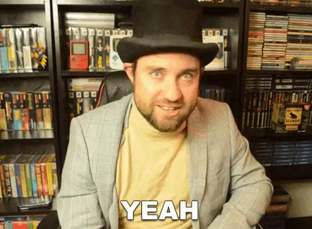 a man in a top hat says yeah in front of a bookshelf