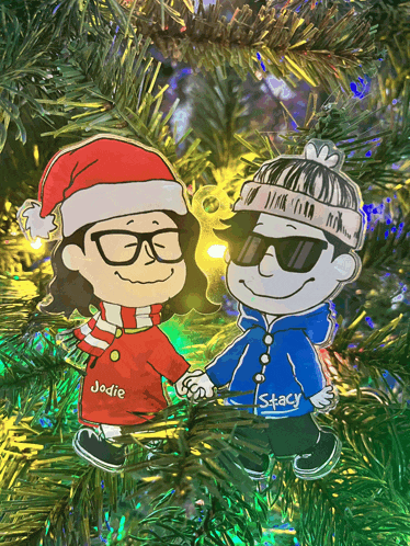 a christmas ornament of jodie and stacy holding hands on a christmas tree
