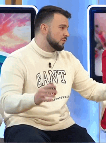 a man wearing a white sweater that says gant