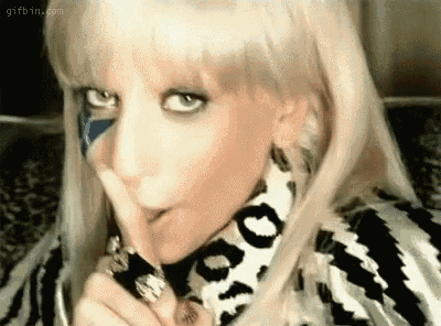 a close up of a woman making a shhh gesture