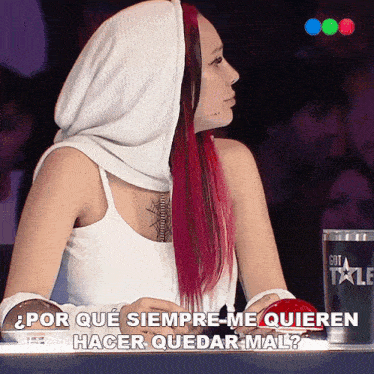 a woman with red hair is sitting in front of a got talent cup