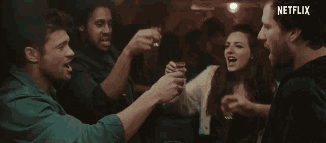a group of people toasting with shot glasses with netflix written on the bottom