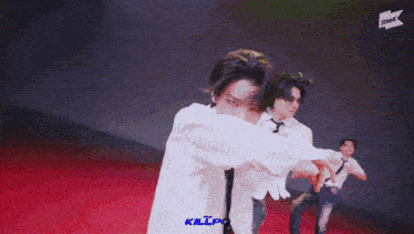 a man in a white shirt and tie is dancing on a red floor
