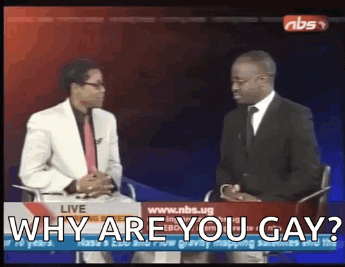 two men are sitting in front of a screen that says " why are you gay " on it