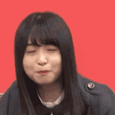a close up of a woman making a funny face while wearing a jacket and tie .