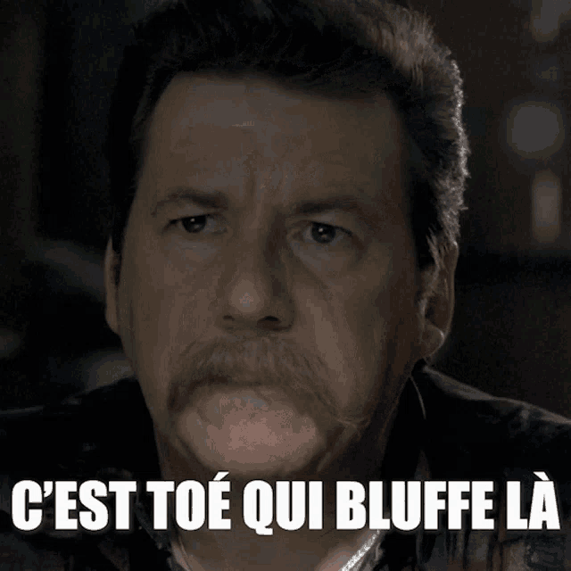 a man with a mustache and the words c'est toe qui bluffe la on his face