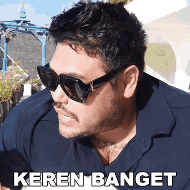 a man wearing sunglasses and a shirt with the word keren banget on it