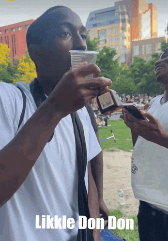a man drinking from a plastic cup with the words likkle don don on the bottom