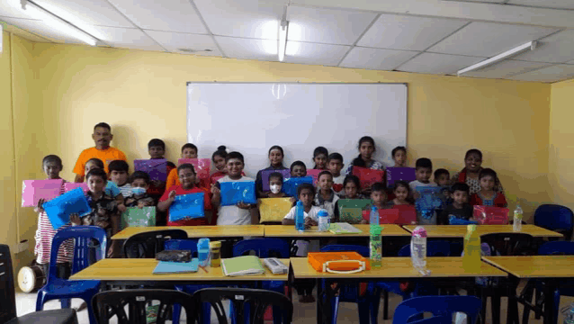a group of children are posing for a picture in front of a whiteboard