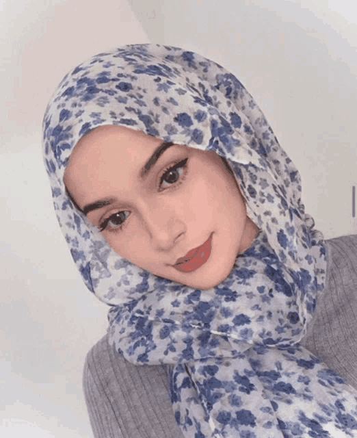 a woman wearing a blue and white floral scarf on her head