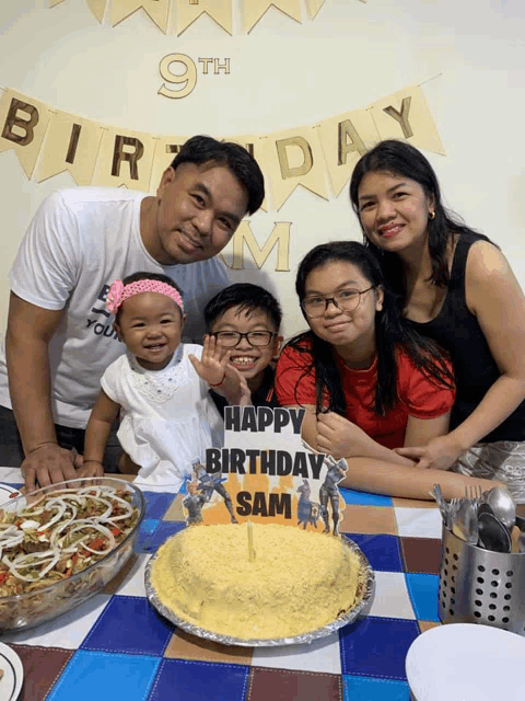 a family poses for a picture in front of a birthday banner