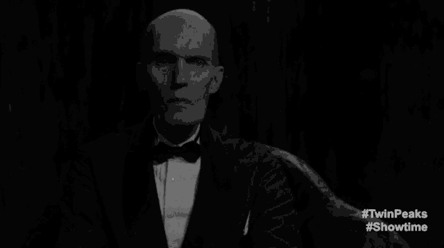 a man in a tuxedo and bow tie is saying agent cooper in a black and white photo .