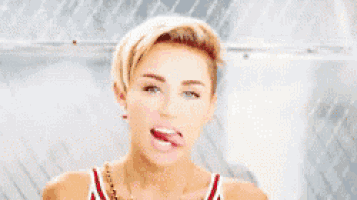a woman is sticking her tongue out while wearing a red and white tank top .
