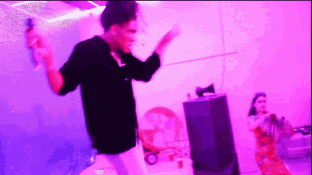 a woman singing into a microphone while another woman dances