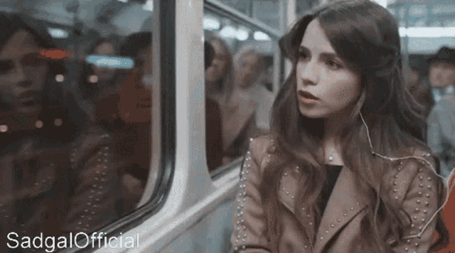 a woman sitting on a train with the words sadgal official written below her