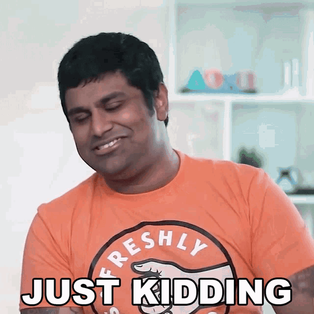 a man wearing an orange shirt that says " freshly " on it