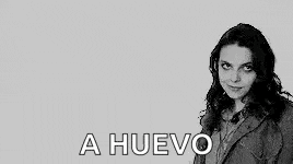 a black and white photo of a woman with long hair and the words `` a huevo '' written in white letters .