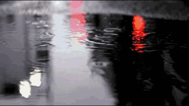 a red light is reflected in a puddle