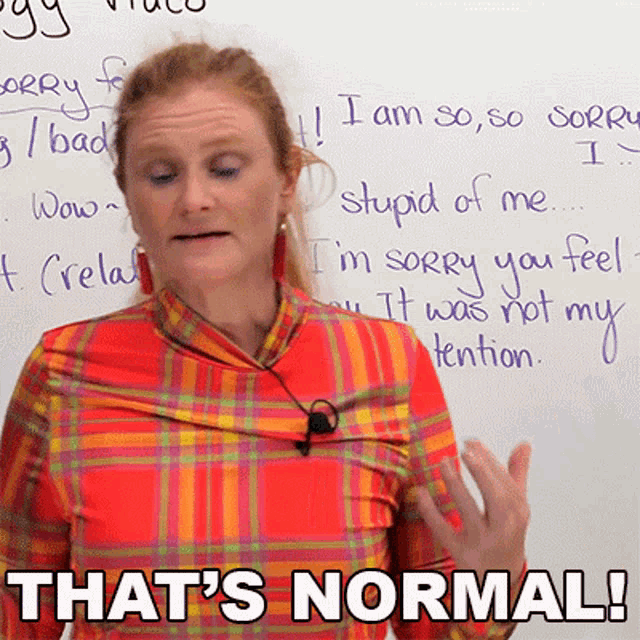 a woman stands in front of a white board with the words that 's normal