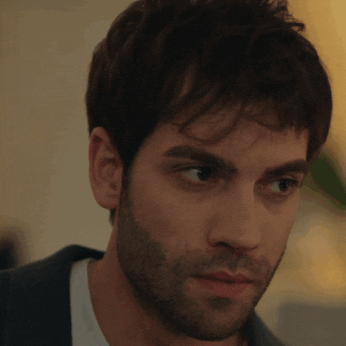 a man with a beard looks at the camera