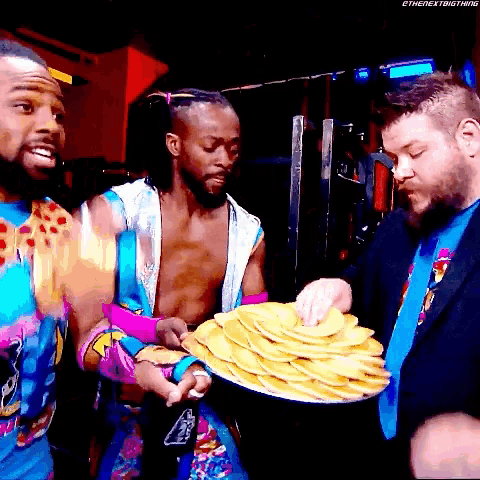 a stack of pancakes is being held by a man in a colorful outfit