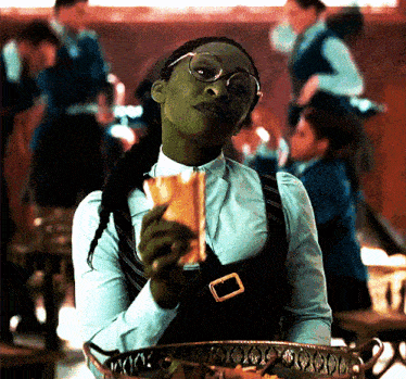 a woman with glasses is holding a piece of food