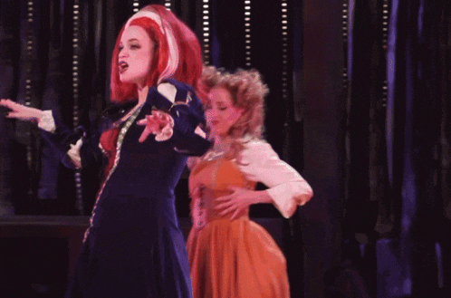 a woman with red hair is singing on stage