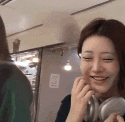 a woman wearing headphones is smiling and talking to another woman .