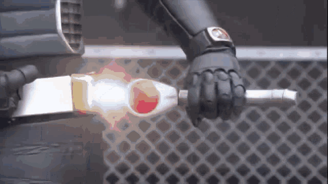 a person in a superhero costume is holding a sword in their hand .