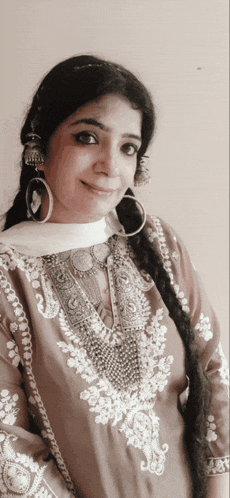 a woman wearing earrings and a necklace is smiling for the camera