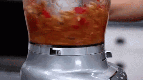 a close up of a blender filled with food on a table
