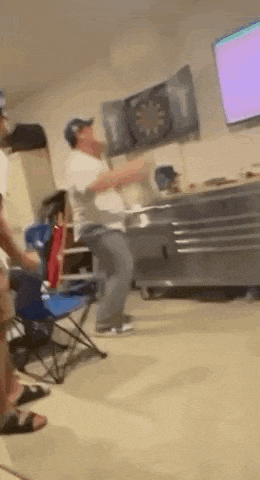 a man is throwing a dart at a dartboard in a room .