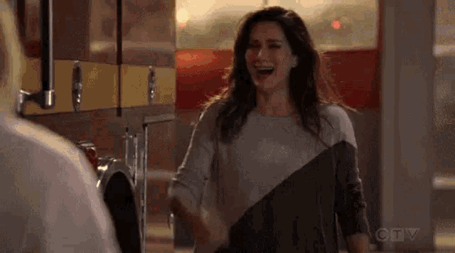 a woman is laughing while standing in front of a fire truck in a kitchen .