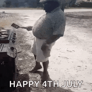 a man is standing in front of a grill cooking food .