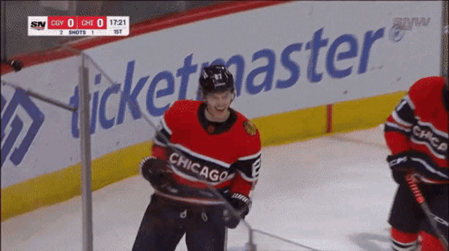 a hockey player wearing a jersey that says chicago stands on the ice