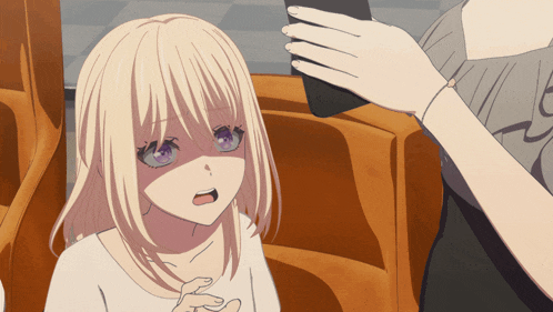 a girl with blonde hair and purple eyes is sitting next to a woman