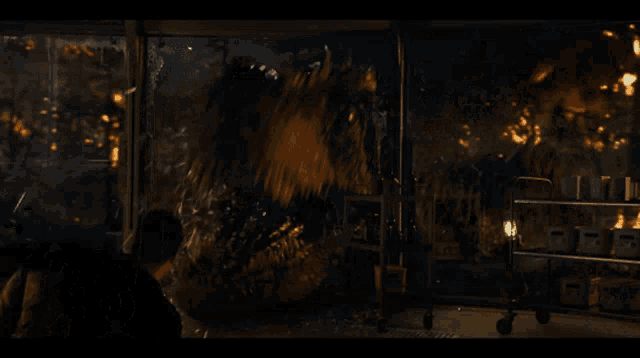 a person standing in a dark room with a broken glass wall