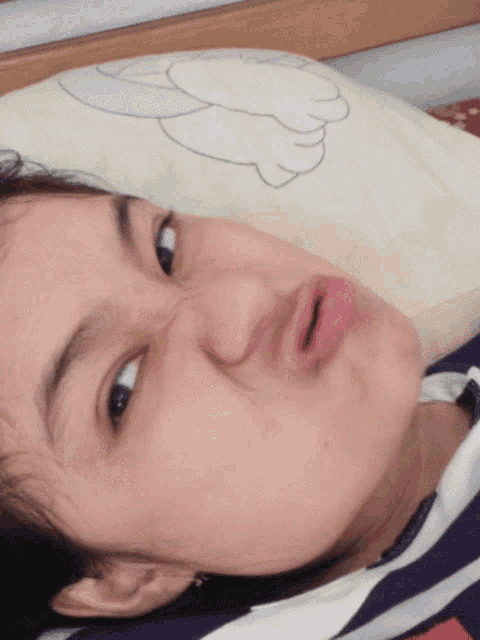a woman laying on a bed making a funny face with her mouth open