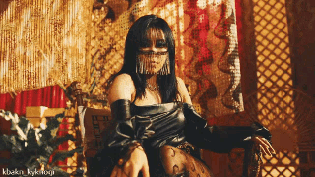 a woman wearing a mask is sitting in a chair with the hashtag kbakn_kyknogi on the bottom