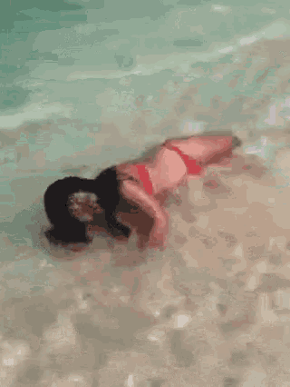 a woman in a bikini is laying in the water
