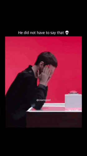 a man covering his face with his hands in front of a red background with the caption he did not have to say that