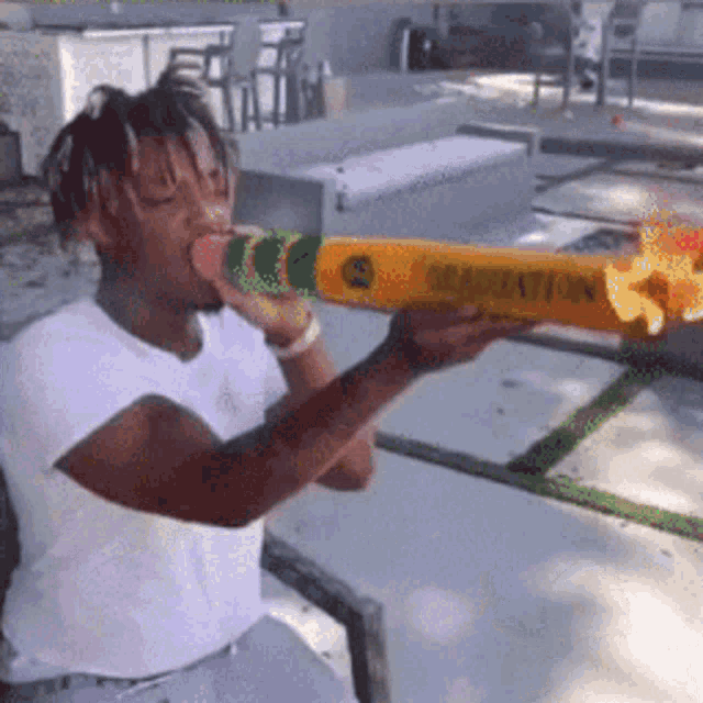 a man in a white shirt is blowing up a graduation candle