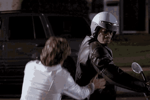 a man wearing a white helmet is being held by another man