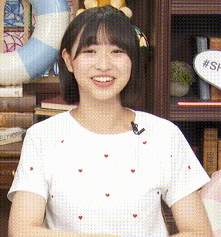 a girl wearing a white shirt with red hearts on it