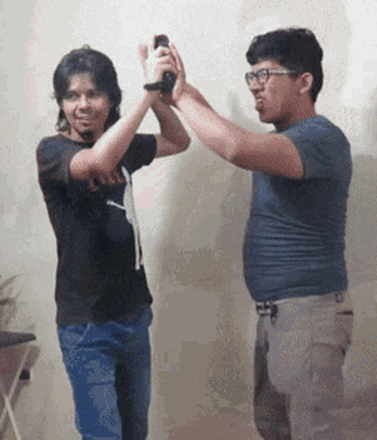 a man wearing a black shirt with the word clash on it holds a wii remote