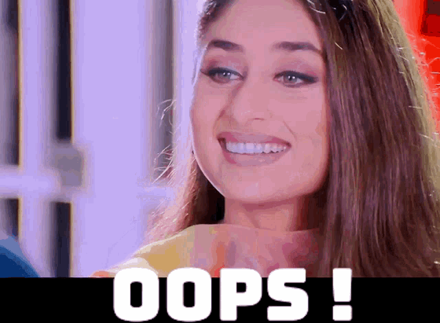 a woman is smiling in front of a sign that says oops !