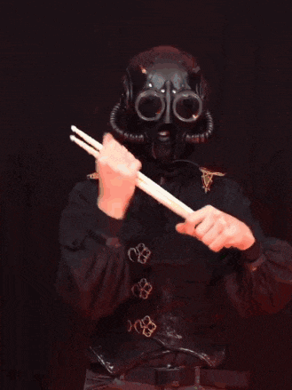 a man in a gas mask is holding a drum stick with the words a nameless ghoul with rhythm above him