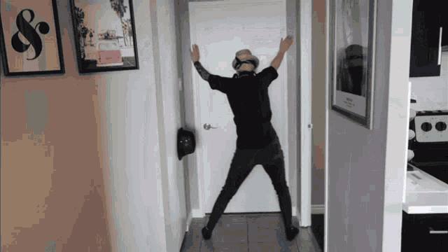 a man is dancing in a hallway in front of a door