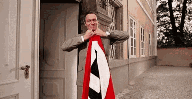 a man is holding a flag in front of a door .