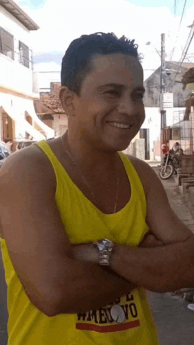 a man wearing a yellow tank top with the word ovo on the front